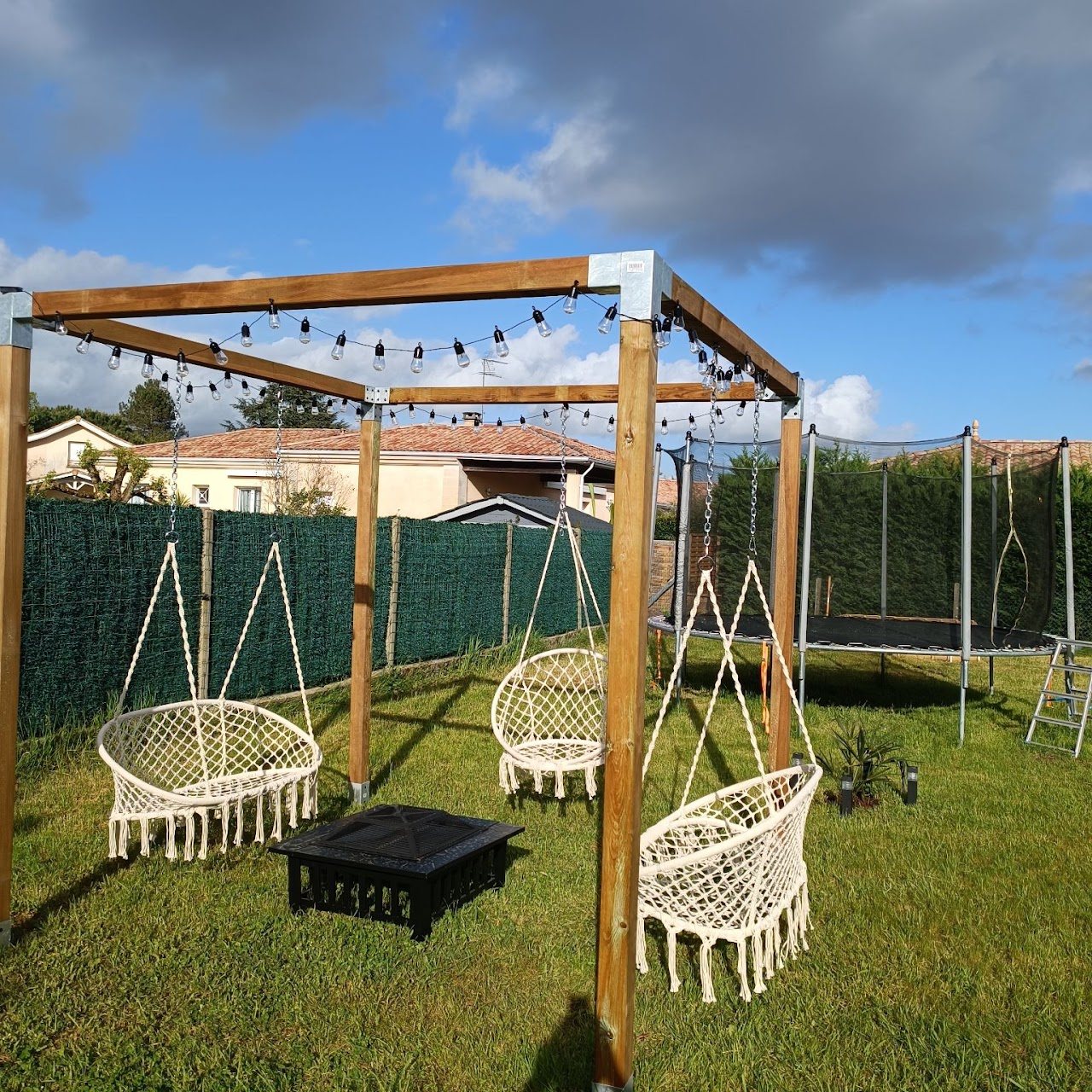 Pergola en bois sur mesure avec balancelles dans un jardin