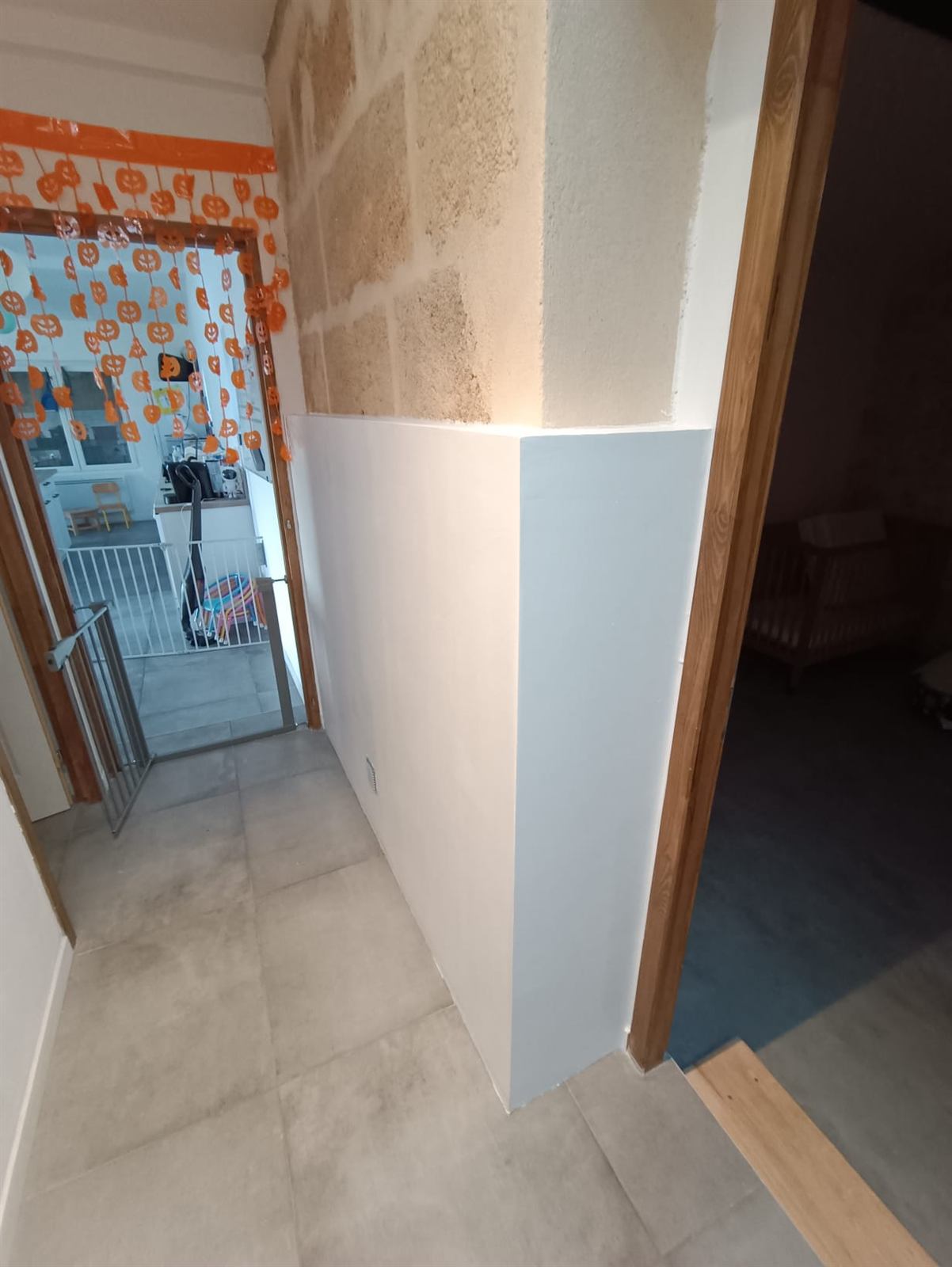 Habillage en plaques de plâtre peint en blanc sous un mur en pierre