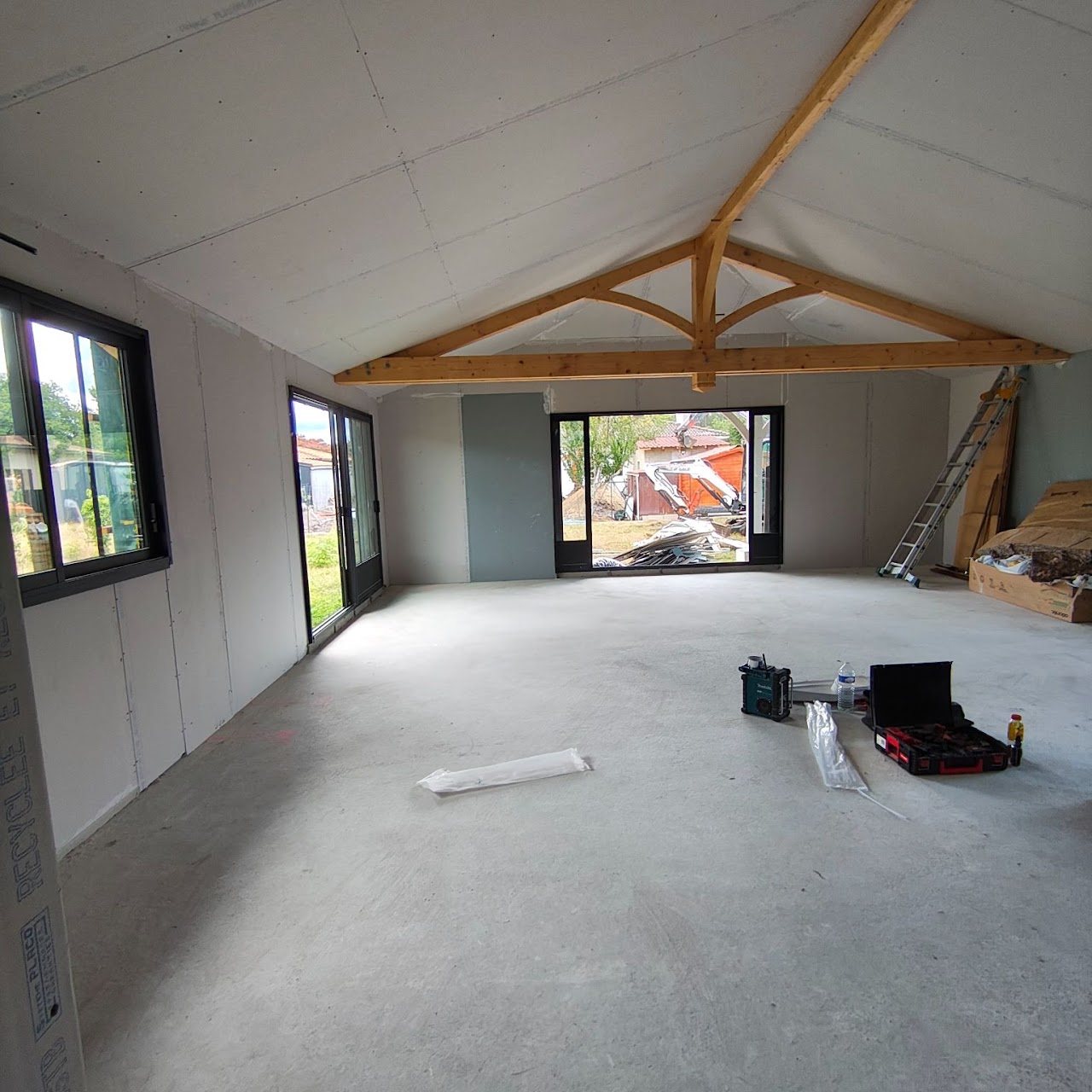 Pièce de vie en plaques de plâtre avec ferme en bois apparente, en maison neuve